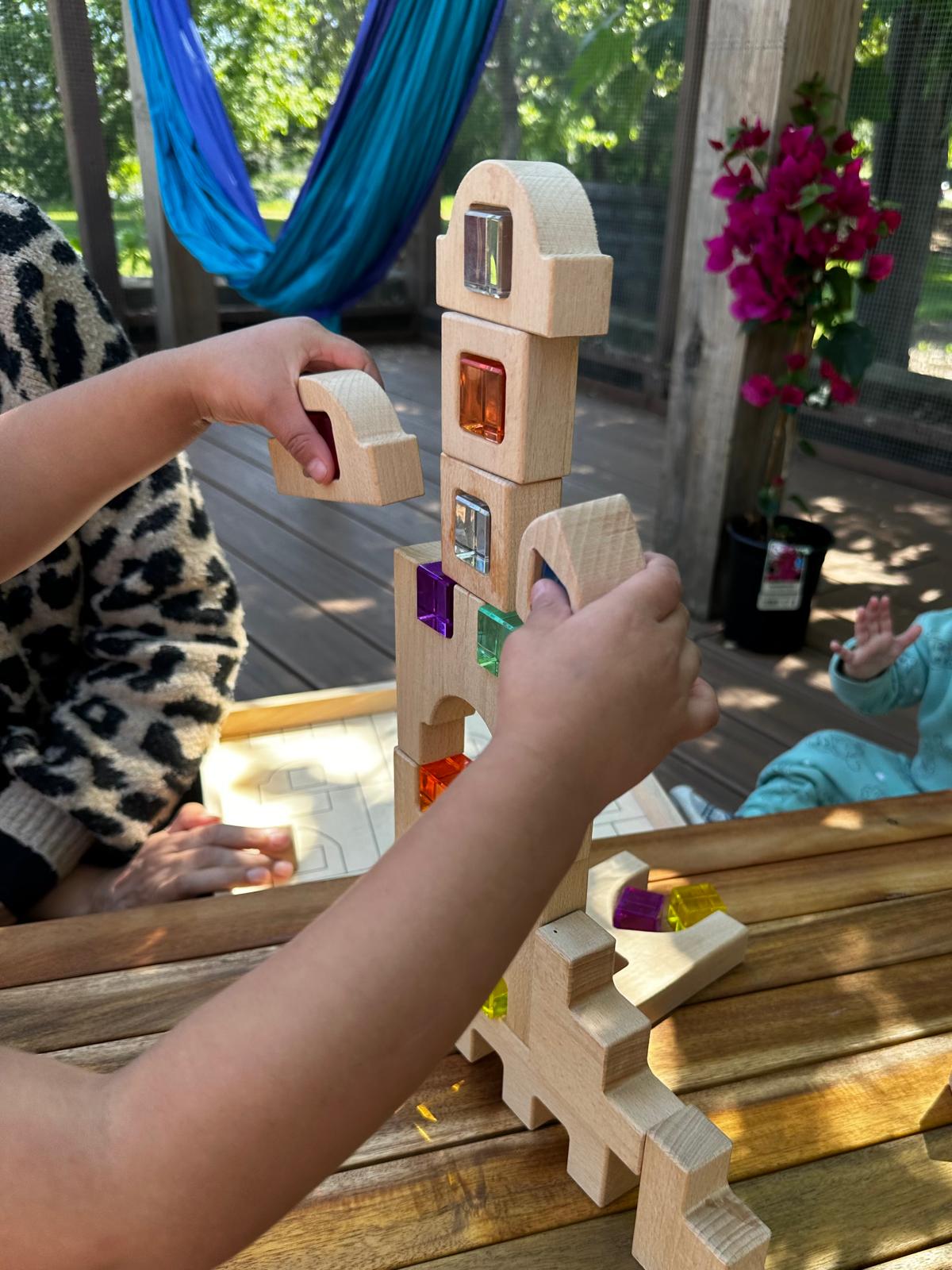 Children building with wooden blocks outdoors